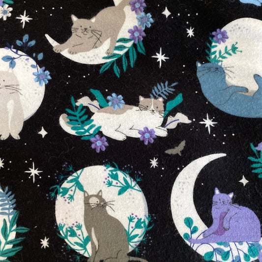 Black background with cats on moons, laying in flowers and very cottage core