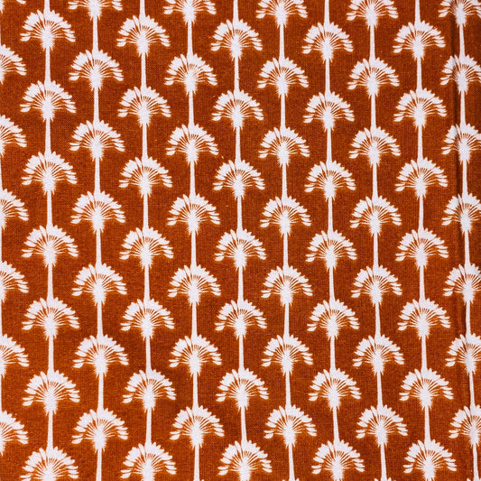 repeated pattern of dandelions on burnt orange background 