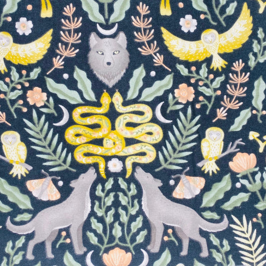 Grey wolves, yellow snakes and yellow and white owls  surrounded by fern and forest foliage 